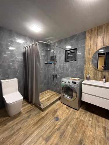 a bathroom with a shower and a washing machine at Debed View in Debed