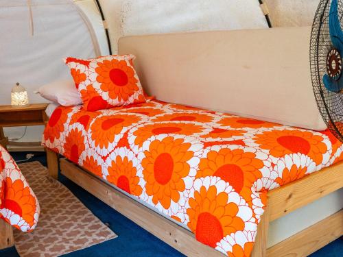 El RosarioLa Colmena Glamping Zangano的一张床，配有橙色和白色的被子和枕头