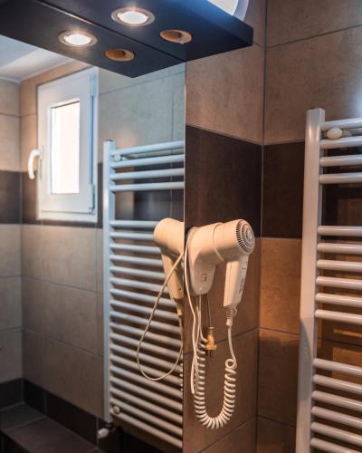 a hair dryer is hanging on a wall in a bathroom at Pensiunea Taka in Orşova