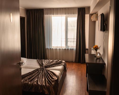 Una habitación de hotel con una cama y una ventana. en Pensiunea Taka, en Orşova