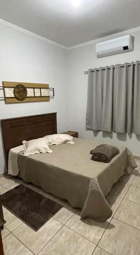 a bedroom with a large bed in a room at Casa Gêmeas 1 in Andradina