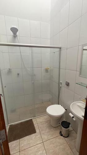 a bathroom with a shower and a toilet and a sink at Casa Gêmeas 1 in Andradina