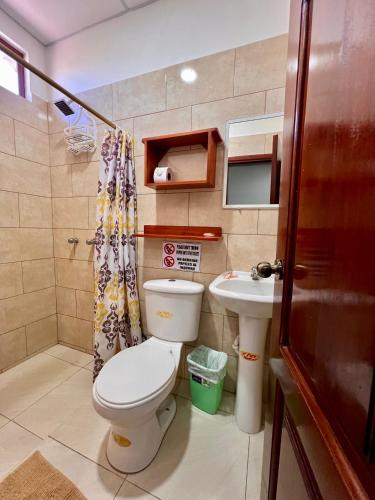 a small bathroom with a toilet and a sink at Hostal Punta Arena in Puerto Villamil