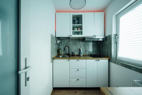 una cucina con mobili bianchi e un lavandino di Urban Escape Studio a Ploieşti