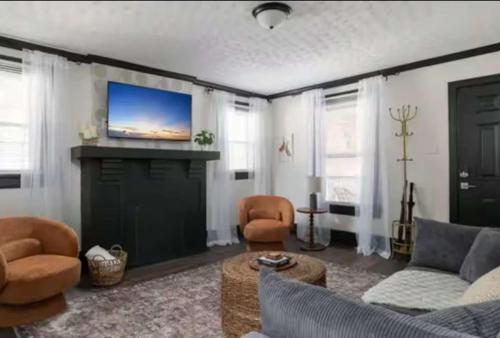 a living room with a couch and a flat screen tv at 3BR Downtown-Old Salem Oasis in Winston-Salem