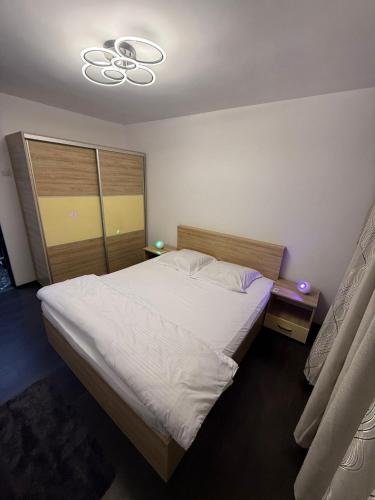 ein Schlafzimmer mit einem großen Bett und einem Kronleuchter in der Unterkunft Sweet home lux RF in Buzău