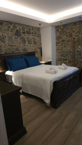 a bedroom with a large bed with blue pillows at Ephrosinis Cottage in Pedoulas