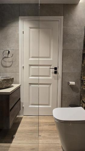 a bathroom with a toilet and a glass door at Ephrosinis Cottage in Pedoulas