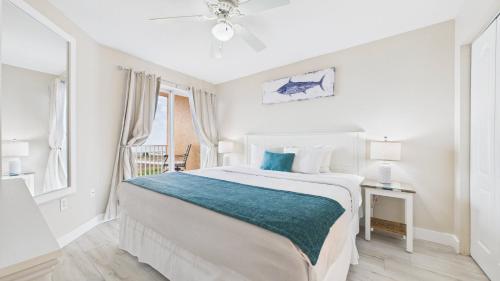 een witte slaapkamer met een groot bed en een raam bij Surf Beach Treasure Island Resort in St Pete Beach