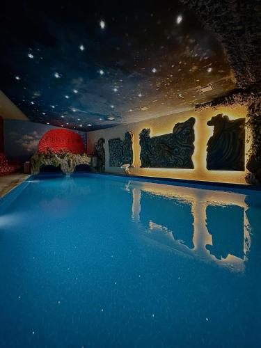 a swimming pool with blue water in a room at Hotel Sunrise and Spa in Čiflik