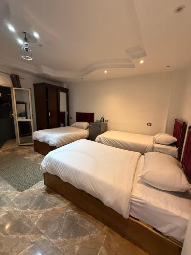 een hotelkamer met drie bedden in een kamer bij Middle East pyramids veiw &spa in Caïro