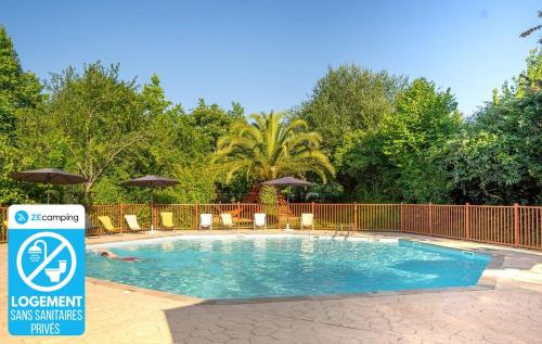 ein Pool mit Stühlen und Sonnenschirmen und eine Person, die schwimmt in der Unterkunft Camping 3 étoiles - Parc aquatique - ccba0ec in Urt