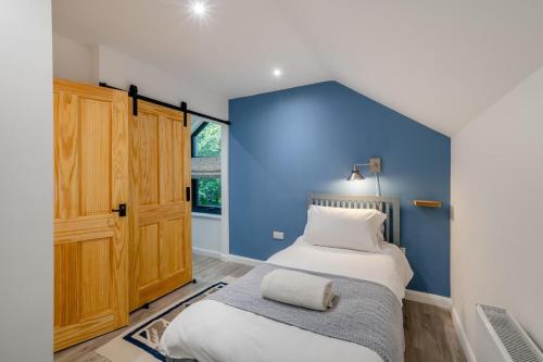 1 Schlafzimmer mit blauer Wand und 2 Betten in der Unterkunft 2 Bed in Melkridge oc-b32221 in Haltwhistle