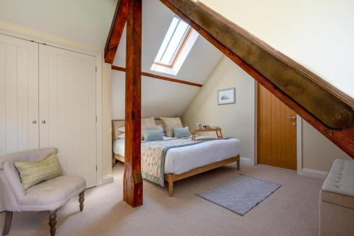 een slaapkamer met een bed en een stoel op zolder bij 4 Bed in Blakeney oc-1948 in Blakeney