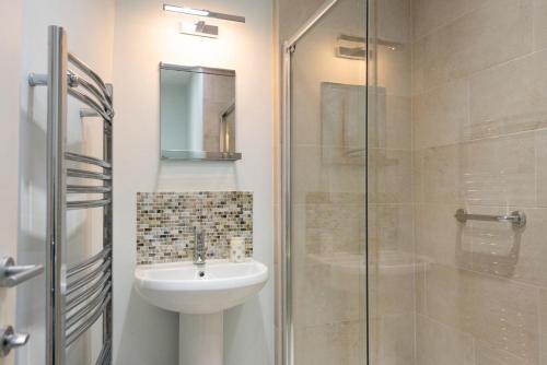 een badkamer met een wastafel en een glazen douche bij 4 Bed in Blakeney oc-1948 in Blakeney