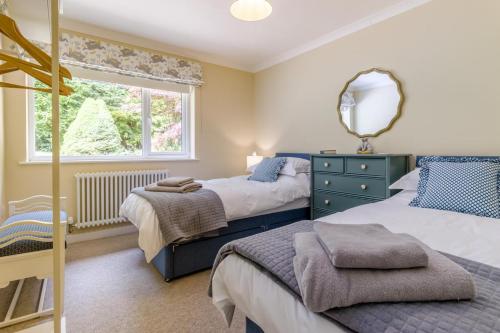 a bedroom with two beds and a mirror and a window at 3 Bed in Llanfyllin oc-i32566 in Llanfyllin