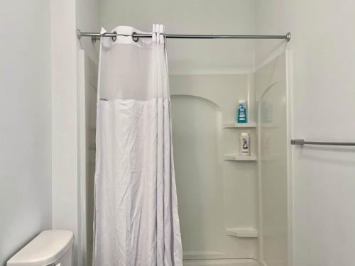 a shower with a white shower curtain in a bathroom at Luxury 4Beds 3Baths 2Balcony Penthouse 542Blvd in Atlanta