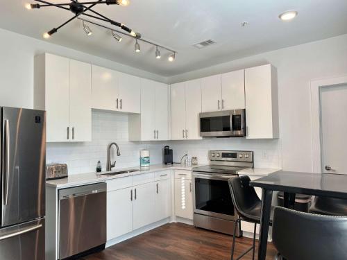 eine Küche mit weißen Schränken und Geräten aus Edelstahl in der Unterkunft Luxury 4Beds 3Baths 2Balcony Penthouse 542Blvd in Atlanta