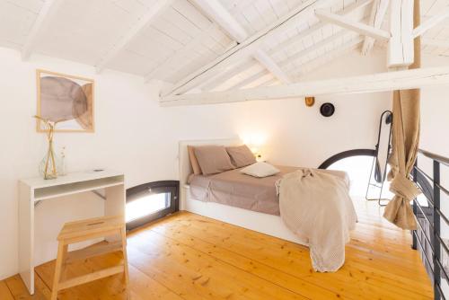 een slaapkamer met een bed en een houten vloer bij Casa Rifa in Serramanna