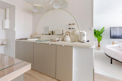 eine Küche mit weißen Schränken und einer Arbeitsplatte in der Unterkunft Suite 2 à 4 personnes lit rond Bergson Stade Zénith in Saint-Étienne