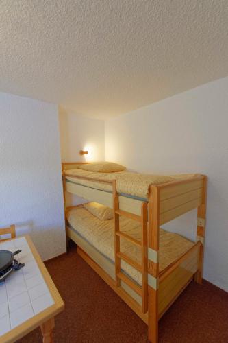 two bunk beds in a room with a table at Studio Serre Chevalier 300m des pistes in Saint-Chaffrey