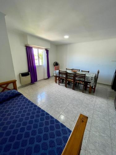 a bedroom with a table and chairs and a dining room at Departamentos Los Manantiales in Villa Gesell