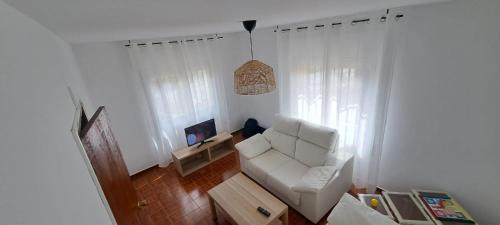 ein Wohnzimmer mit einem weißen Sofa und einem Sessel in der Unterkunft Casa América in Labra