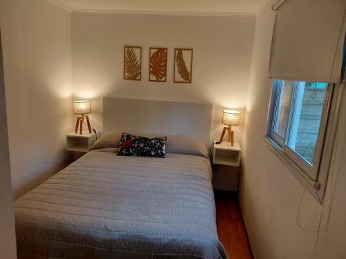 una camera da letto con un letto con due lampade su due tavoli di CABAÑA MOAI a Mar del Plata