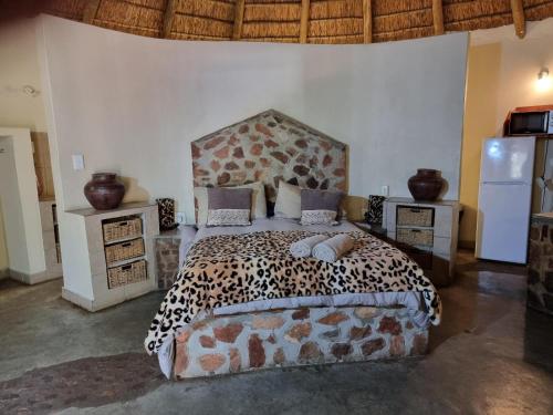 een slaapkamer met een bed met luipaardprint en 2 nachtkastjes bij Out of Africa Lodge in Hartbeespoort