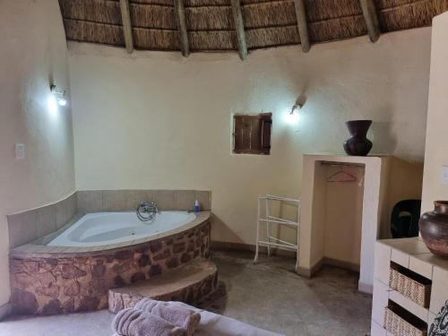 een badkamer met een bad in een kamer bij Out of Africa Lodge in Hartbeespoort