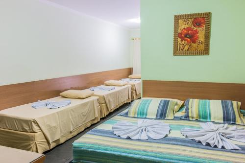 a group of three beds in a room at Hotel Santa Fé in Itupeva