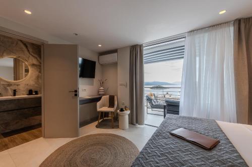 a bedroom with a bed and a view of the ocean at Noma Suites Tolo in Tolo