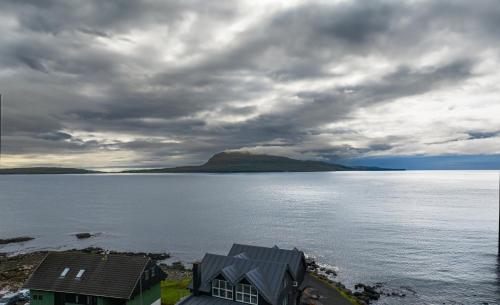 a view of a large body of water with a house at Hotel Djurhuus in Tórshavn