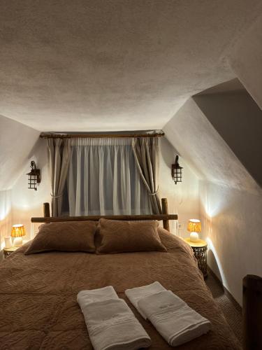 ein Schlafzimmer mit einem Bett, auf dem zwei Handtücher liegen in der Unterkunft Casa Plaiul Cailor: Rustic Mountain Hideaway in Proviţa de Sus