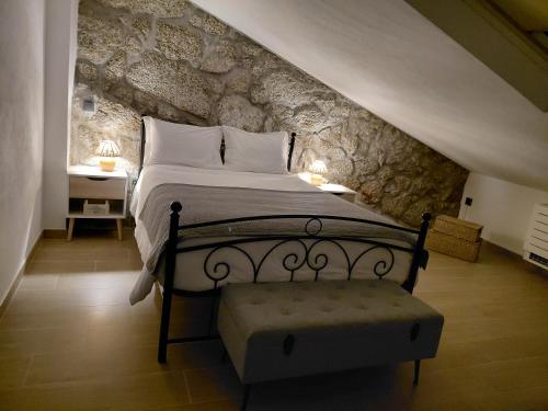 ein Schlafzimmer mit einem Bett mit einer Steinwand in der Unterkunft Casa da Póvoa in Seia