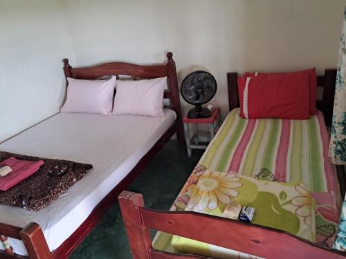 una camera con 2 letti e un ventilatore di Pousada do macuco a São João Batista do Glória