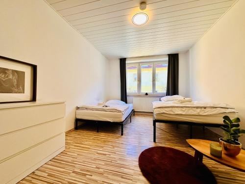 a room with two beds and a table and a window at Red Room in Schottwien