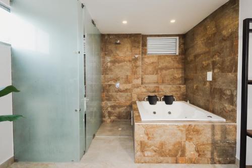 a bathroom with a bath tub and a shower at Hotel El Descanso in Fusagasuga