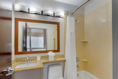 a bathroom with a sink and a toilet and a mirror at Comfort Inn in Staten Island