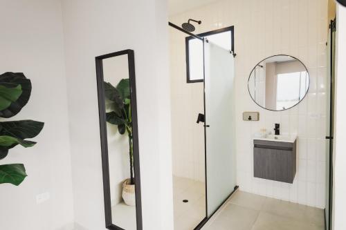 a bathroom with a shower with a mirror and a sink at Hotel El Descanso in Fusagasuga