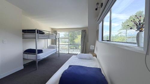 een slaapkamer met twee stapelbedden en een raam bij Mt Aspiring Home in Wanaka