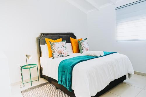 a bedroom with a bed with orange and blue pillows at Modern Nest in Sandton