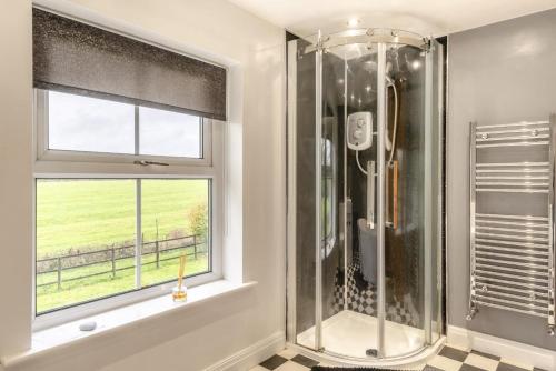 een douchecabine in een badkamer met een raam bij 5 Bed in Utterby oc-t34067 in Fotherby