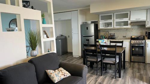 a living room with a couch and a table in a kitchen at Casa Axhé Rosarito in Rosarito Beach