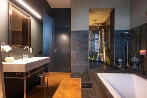 een badkamer met een wastafel en een ligbad bij Civiltà Boutique in Antwerpen