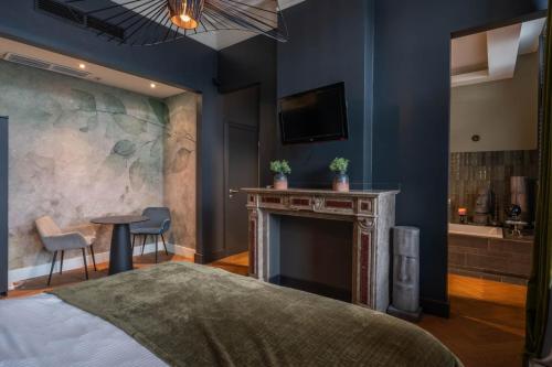 een slaapkamer met een open haard, een bed en een tv bij Civiltà Boutique in Antwerpen