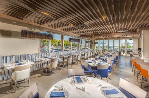a dining room with white tables and blue chairs at Living Water Resort & Spa in Collingwood