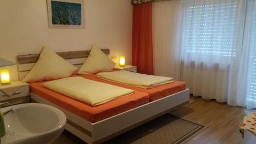 a bedroom with two beds and a sink at Landhaus Irma in Bad Füssing