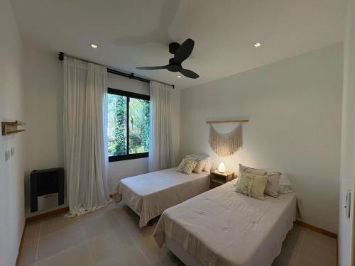 a bedroom with two beds and a ceiling fan at Casa Calma Cariló in Carilo