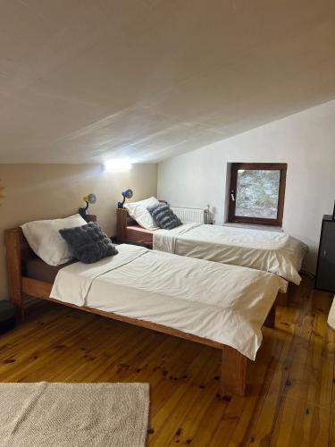 twee bedden in een kamer met houten vloeren bij TopHill Villa in Kratovo